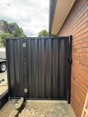 Colorbond side gate beside a brick home