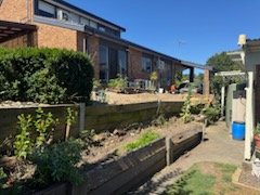 Timber sleeper retaining garden beds behind a home