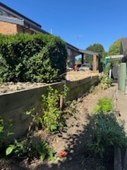 Timber sleeper garden bed along a fence line