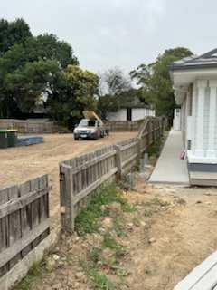 Old grey paling fence beside a white home